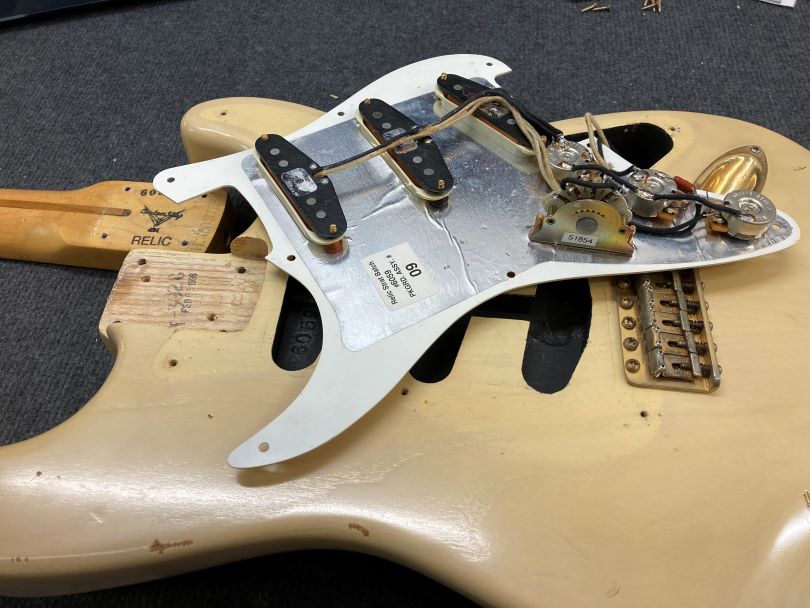 The pickguard with the electronics is a separate part of the guitar
