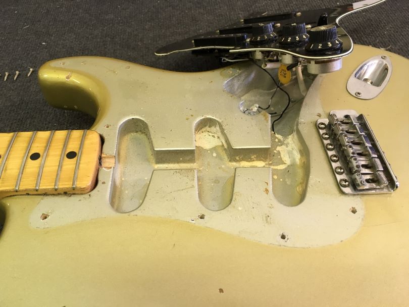 Under the pickguard, the original shade of Silver lacquer has been preserved.