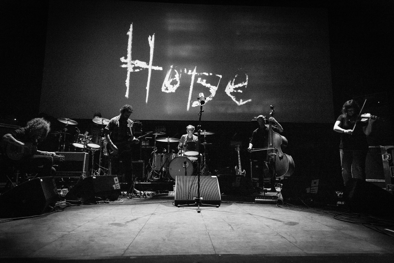 Godspeed You! Black Emperor performing live at Roadburn Festival 2018 | Photo: Grywnn, CC BY-SA 4.0 via Wikimedia Commons Godspeed You! Black Emperor performing live at Roadburn Festival 2018 | Photo: Grywnn, CC BY-SA 4.0 via Wikimedia Commons