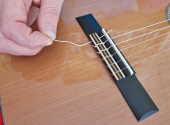 Unlike metal strings, nylon strings are tied to the bridge.