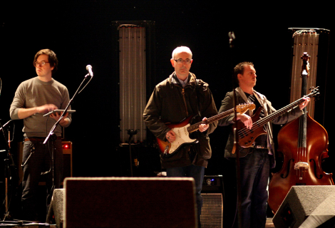 Jolyon Thomas (laptop), Dik Evans (electric guitar) and Dave Mooney (bass guitar) performing at Gavin Friday's performance in Dublin, in 2011 | Photo by Caroline van Oosten de Boer (CC 3.0)
