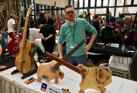 Mike Sankey with his work at the fair. | Photo: Sankey Guitars Facebook